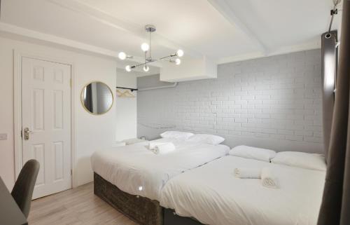 伦敦Anchor Guest House的白色墙壁客房的两张床