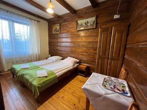 乔尔什滕Noclegi NADZAMCZE的一间带两张床铺的卧室,位于带木墙的房间内