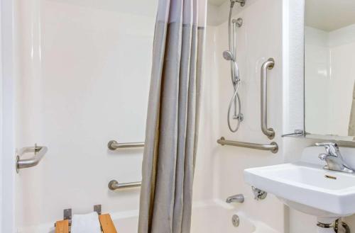 凤凰城第6凤凰城西汽车旅馆的浴室配有淋浴帘和盥洗盆。