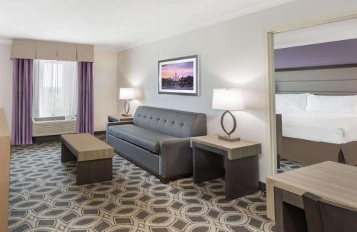 新奥尔良新奥尔良东温德姆花园酒店的酒店客房,配有床和沙发