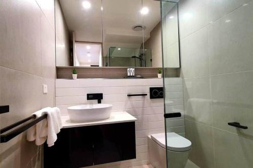 墨尔本Flagstaff Hill West Melbourne的一间带水槽、卫生间和镜子的浴室