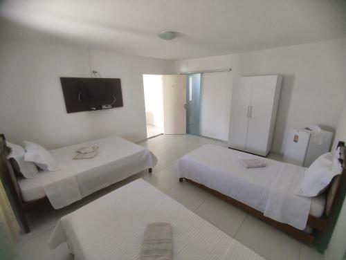 皮拉尼亚斯Pousada Marihá的酒店客房设有两张床和一台平面电视。
