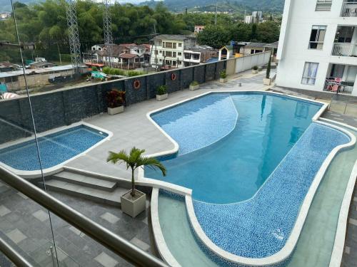 多斯克布拉达斯Hermoso apto con piscina y parqueadero privado的享有大楼顶部游泳池的景色