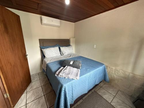帕罗卡Recanto Pé na Areia SC的一间卧室配有一张蓝色的床,上面有毛巾