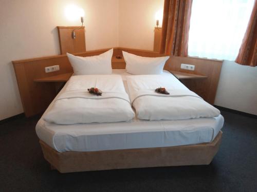 伊德施泰因Hotel Sonne - Haus 2的一间卧室配有一张白色大床,床上有鲜花