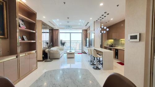 胡志明市Vinhome Central Park Apartment的厨房以及带玻璃桌的起居室。