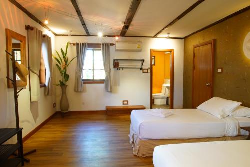 清迈Rimsuan Garden Home的酒店客房设有两张床和窗户。