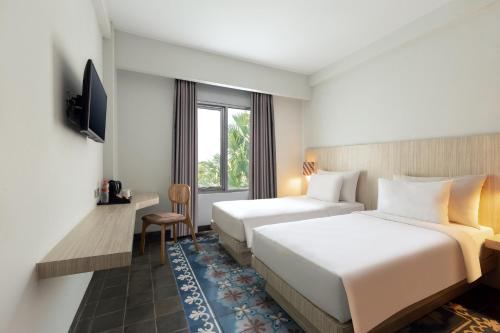 日惹日惹布尔扎酒店的酒店客房设有两张床和电视。