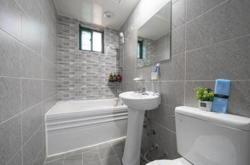 仁川市Alps Motel的浴室配有盥洗盆、卫生间和浴缸。