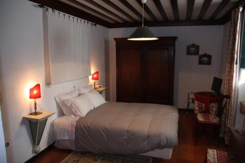 维拉·雷阿尔卡萨达奎因塔马丁霍酒店的一间卧室配有一张带两盏灯和一张桌子的床。
