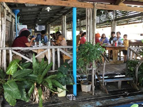 Ban KlangHomestay&ChaoleySeafoodrestaurant的一群坐在餐厅桌子上的人