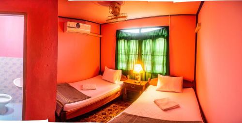 Ban DonsômXaymountry Don Khon City Center Residence and Guesthouse的小房间设有两张床和窗户