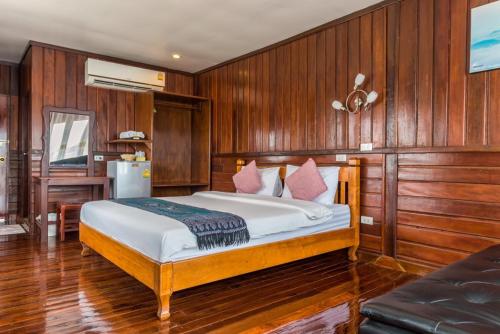 Ban Mai Ta SaengRiverside Chiangkhan的一间卧室配有一张木镶板墙床