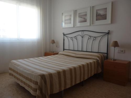 迈阿密普拉特亚JOYAPARTMENTS La Joya的一间卧室配有一张带条纹毯子的床和窗户