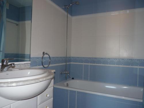 迈阿密普拉特亚JOYAPARTMENTS La Joya的蓝色和白色的浴室设有水槽和浴缸。