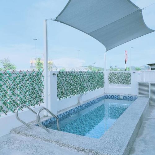 Bandar Puncak AlamPrima Guest House - Puncak Alam Homestay Mus-lim friendly的一个带遮阳伞的游泳池