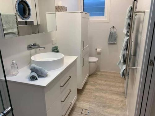 科莱特HighTide- luxury apartment, almost on the beach.的白色的浴室设有水槽和卫生间。