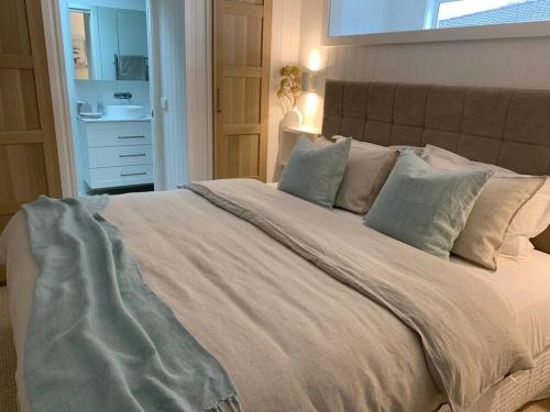 科莱特HighTide- luxury apartment, almost on the beach.的卧室配有带枕头的大型白色床