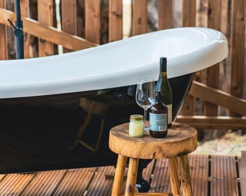 圣海伦斯Glamping 148 Tasmania的冲浪板和桌子上的两瓶葡萄酒
