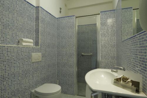 迪亚诺马里纳Hotel Miramare的蓝色瓷砖浴室设有卫生间和水槽