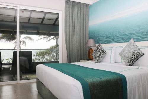 尼甘布Earl's Regent Negombo的一间卧室设有一张大床和一个大窗户