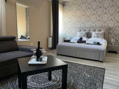 埃格尔Végvári Hotel Eger的一间卧室配有一张床、一张沙发和一张桌子