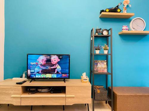 峇六拜Cozy 3BR Apartment with Free Netflix的木质娱乐中心顶部的平面电视