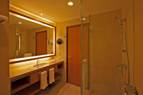 仰光Shangri-La Serviced Apartments, Yangon的带淋浴、盥洗盆和镜子的浴室