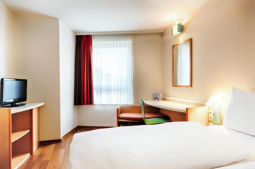 杜塞尔多夫B&B Hotel Düsseldorf-Hbf的配有一张床和一张书桌的酒店客房