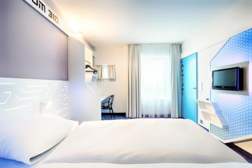 不莱梅B&B Hotel Bremen-Altstadt的一间酒店客房,配有一张床和一台电视