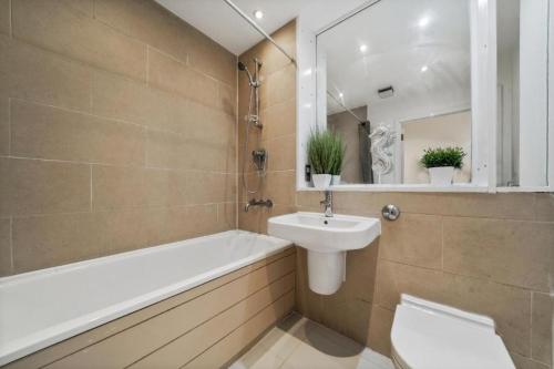 伦敦Modern1Bed Apartment London Camberwell Denmark Champion Hill的一间带水槽、浴缸和卫生间的浴室