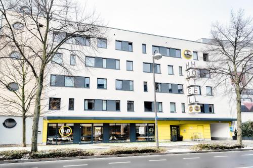 波恩B&B Hotel Bonn-West的白色的大建筑,有黄色的外墙
