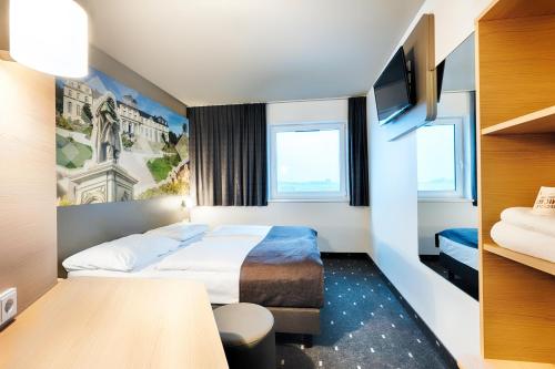 波恩B&B Hotel Bonn-West的一间酒店客房,配有一张床和一台电视