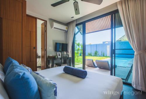邦涛海滩Two Bedroom Wings Pool Villa的一间卧室配有一张床,享有庭院的景色