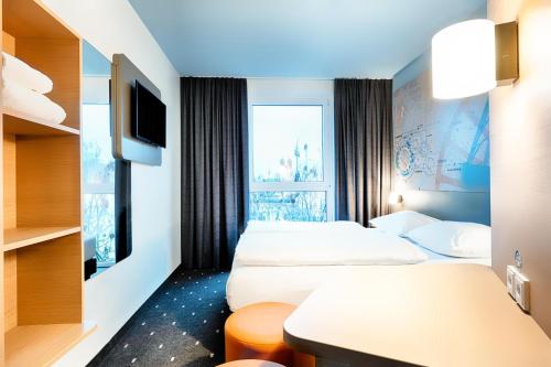波鸿B&B Hotel Bochum-City的一间酒店客房,设有两张床和电视