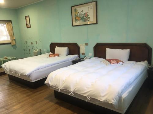 仁爱乡清境柏克莱景观民宿的配有白色床单的客房内的两张床