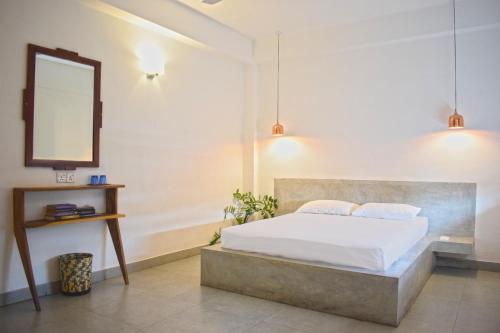 科伦坡City Beds Colombo的一间卧室配有一张带镜子和吊灯的床