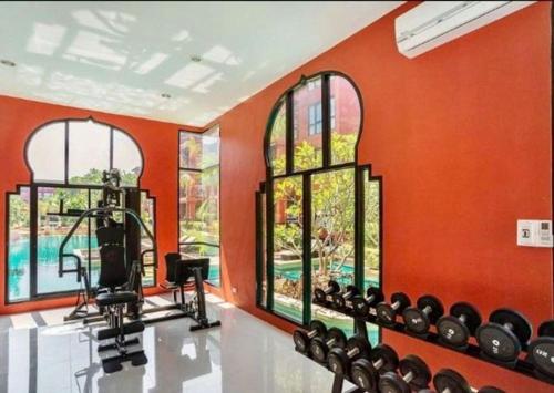 华欣Cozy resort-style condominium的橙色的房间,设有健身房,配备许多健身器材