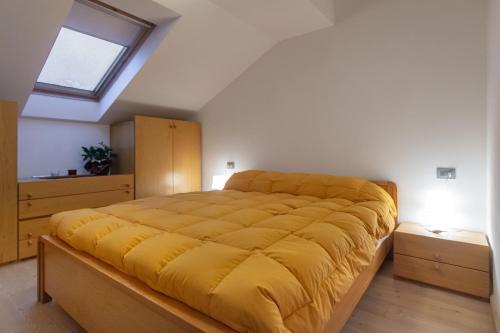 普雷达佐DolomiApartments - Appartamento Orso Bruno的一间卧室配有一张带黄色毯子的大床