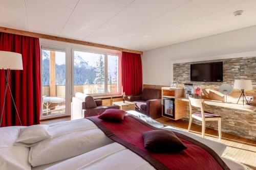 阿罗萨Blatter's Arosa Hotel & Bella Vista SPA的一间带大床的卧室和一间客厅