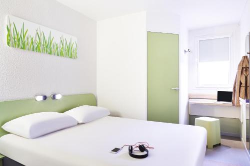 马诺斯克Ibis Budget Manosque Cadarache的卧室配有白色的床和绿色的墙壁