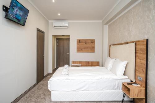 桑丹斯基Hotel CITY Sandanski的卧室配有一张白色大床和电视。