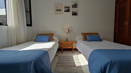蒂亚斯Casa Margarita的两张床铺位于带桌子的房间
