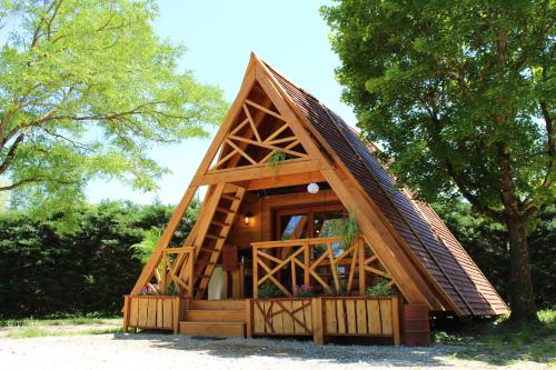 RecoubeauHabitat Créateur - Hébergements insolites au camping municipal "Les Ecureuils"的茅草屋顶的小树屋