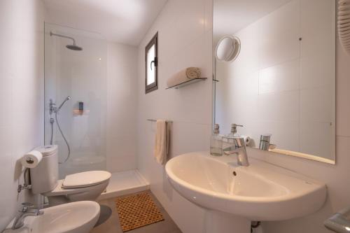 米乔尔海滩Hostal Aigua Clara的白色的浴室设有水槽和卫生间。