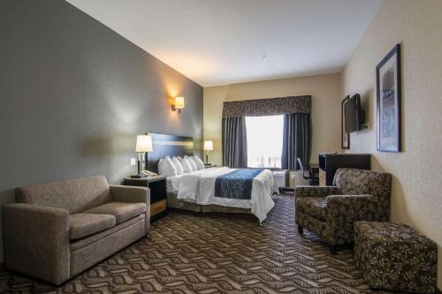 萨斯喀彻温堡萨斯喀彻温堡康福特茵酒店的酒店客房,配有一张床和两把椅子