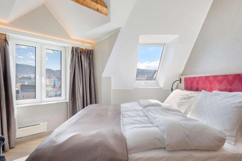 卑尔根Bergen Harbour Hotel, WorldHotels Crafted的一间卧室设有一张大床和两个窗户