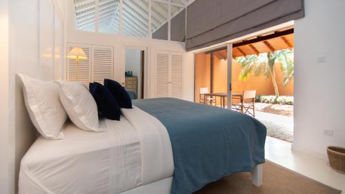 坦加拉Maya Tangalle的一间卧室配有一张带蓝色和白色枕头的床