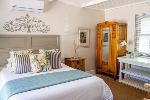 帕尔Madeliefie Guest Accommodation的一间卧室配有一张大床和一架钢琴
