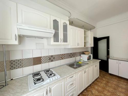 敖德萨DAY & NIGHT的厨房配有白色橱柜和炉灶烤箱。